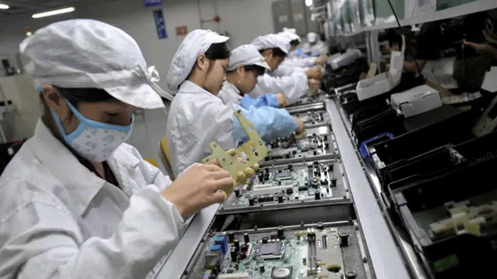 عمال صينيون يجمعون المكونات الإلكترونية في مصنع التكنولوجيا التايوانية العملاقة فوكسكون في شنتشن، الصين