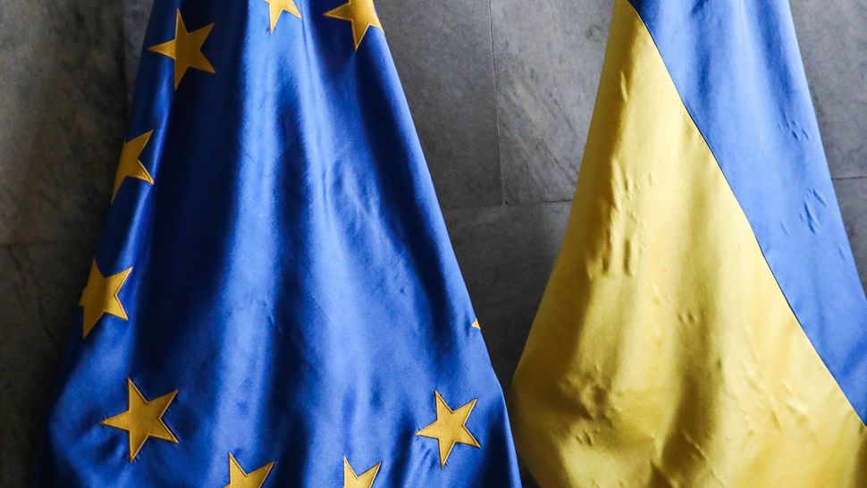 علما أوكرانيا (يمين) والاتحاد الأوروبي