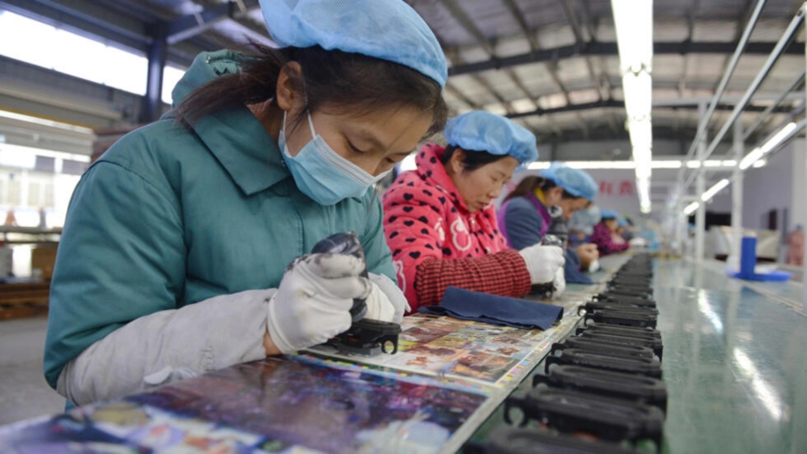 عاملات في مصنع لانتاج مكبرات الصوت في مدينة فويانغ، بمقاطعة أنهوي شرق الصين في 30 نوفمبر 2022 