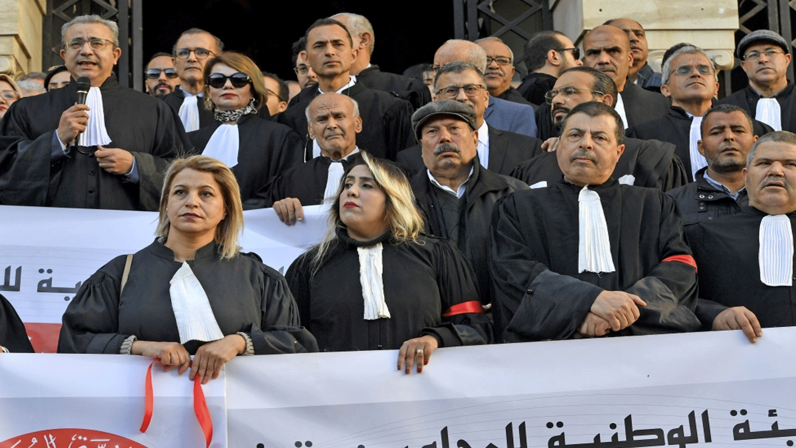 المحامون التونسيون يرتدون شارة حمراء خلال جلسة للمحامين احتجاجًا على قانون المالية الجديد، أمام محكمة تونس، في 5 كانون الثاني\يناير 2023.