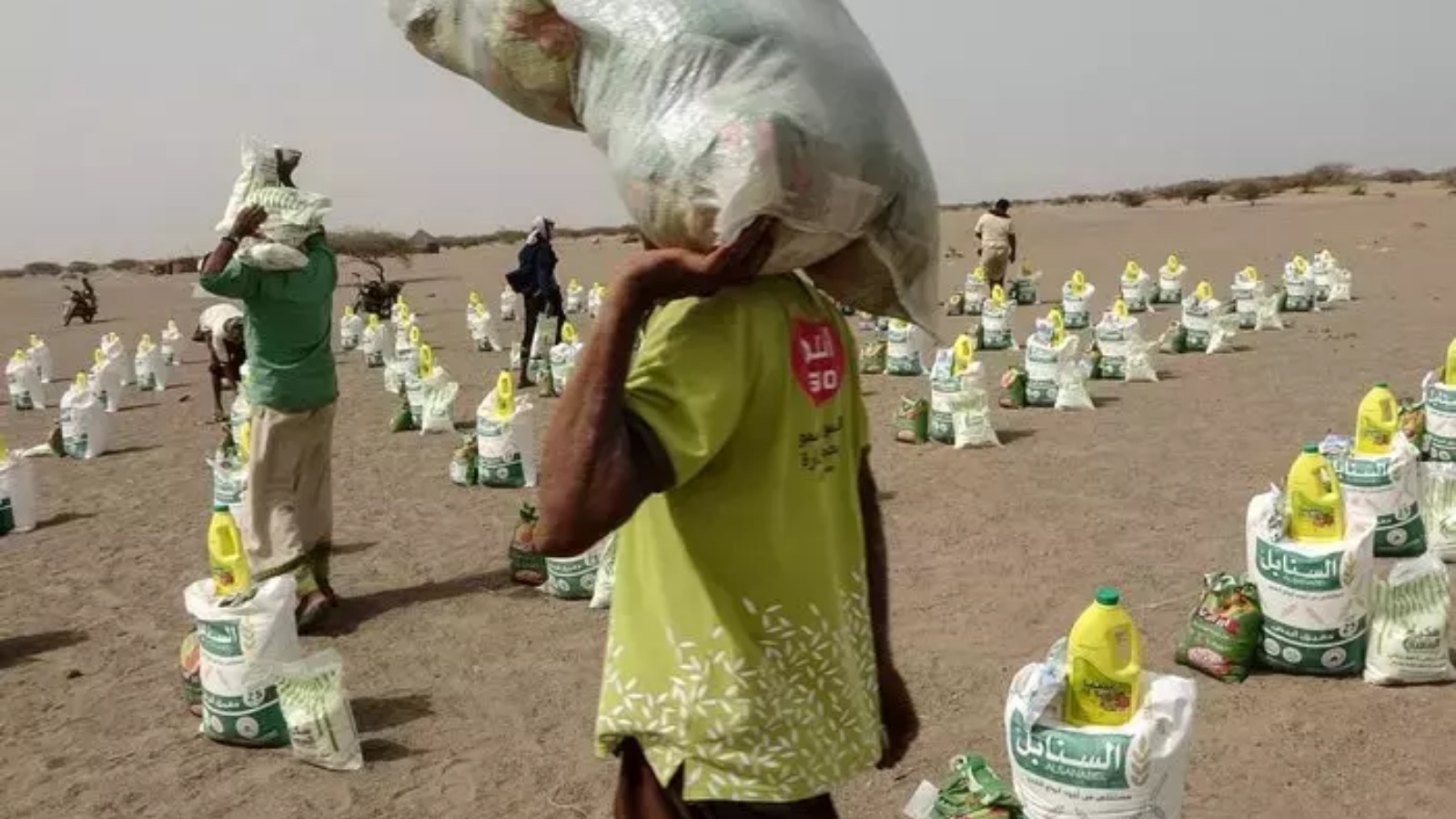 نازحون يمنيون يتلقون الطعام والإمدادات في مخيم بمديرية حيس بالحديدة في 6 يوليو 2022