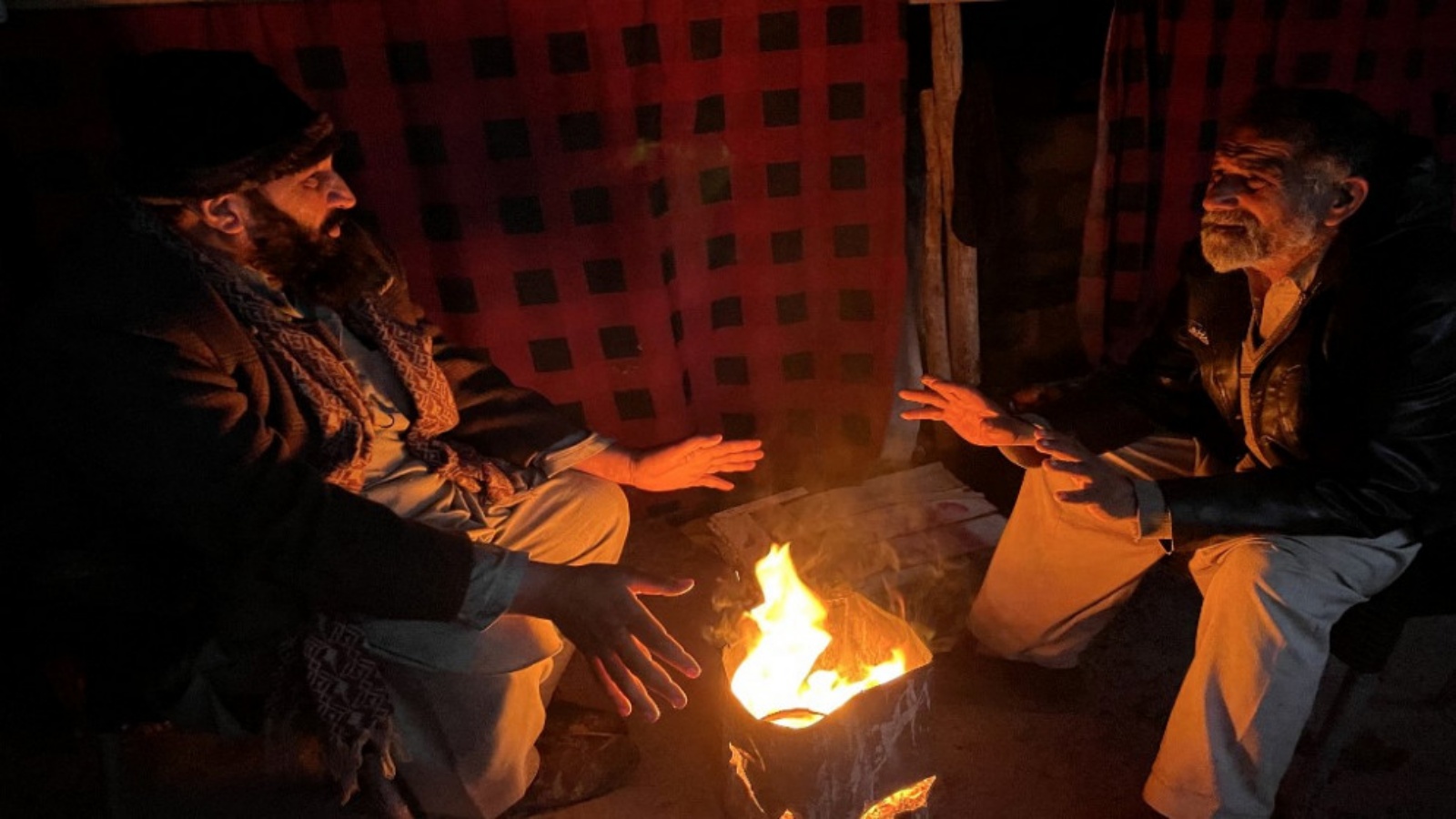 باكستانيون يشعلون نارًا لتدفئة أنفسهم أثناء انقطاع التيار الكهربائي في جميع أنحاء البلاد، في مظفر أباد 23 يناير 2023