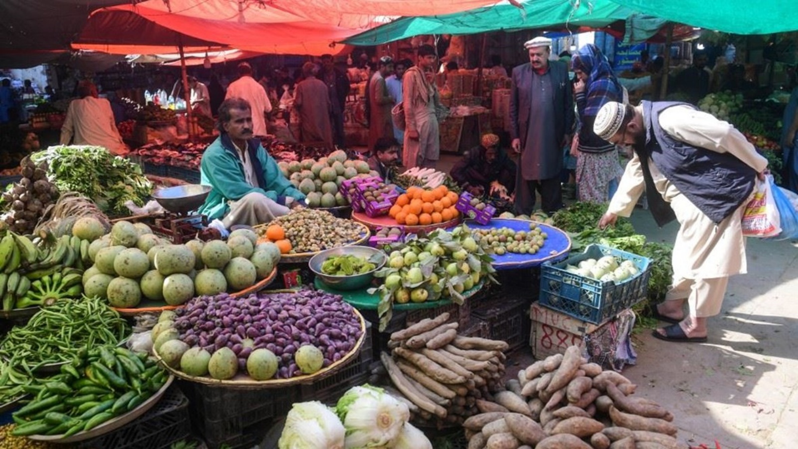 باكستانيون يشترون الخضار من سوق في مدينة كراتشي الساحلية.