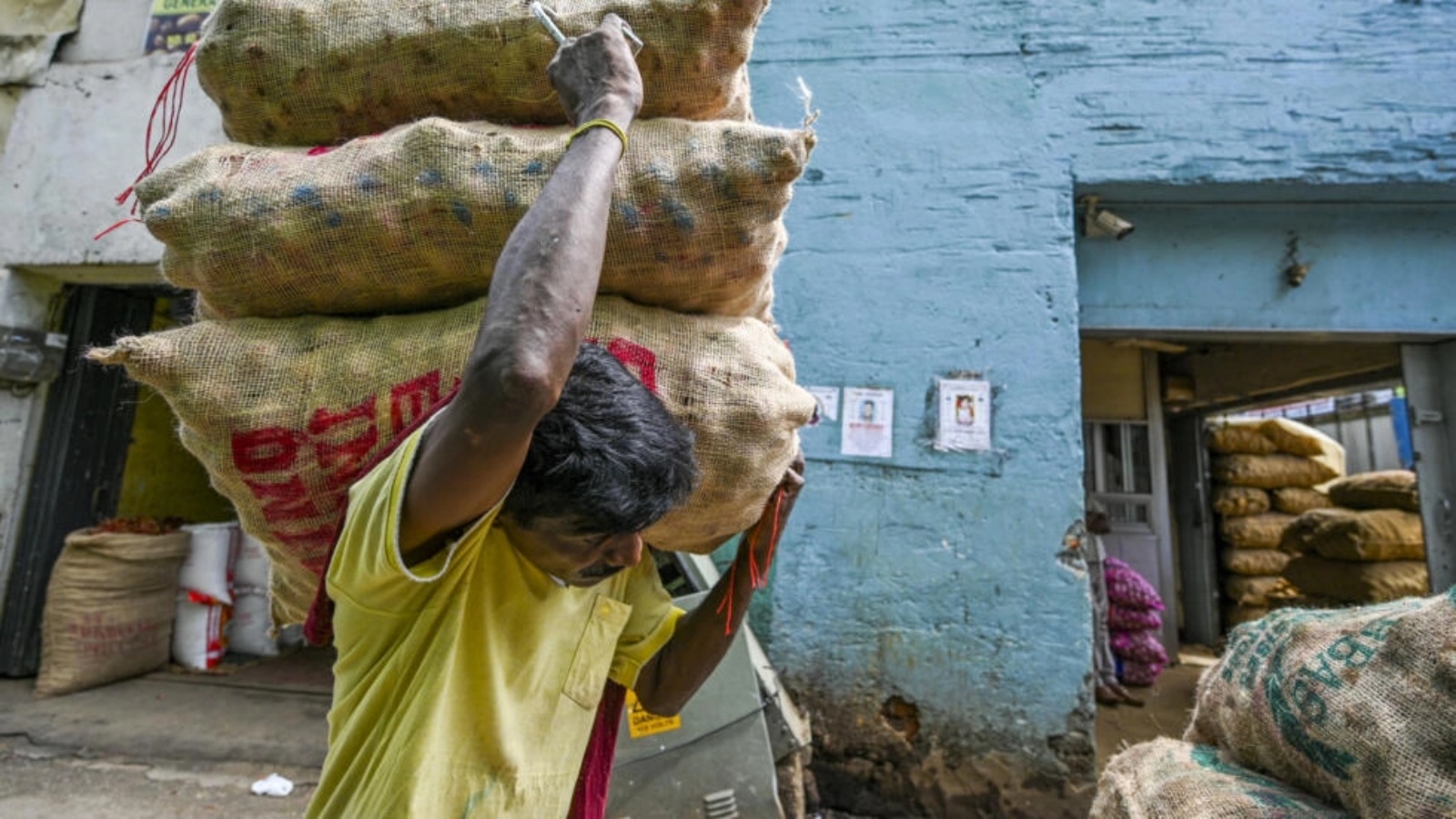 عامل ينقل أكياسًا من البطاطس في سوق في كولومبو منتصف نوفمبر 2022 