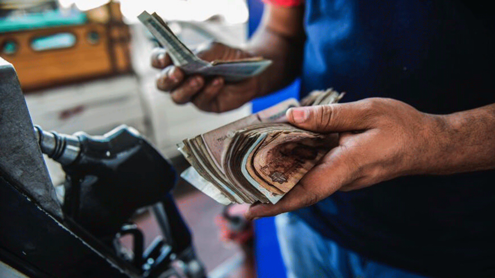 صورة أرشيفية لعامل محطة بنزين مصري يحصي الأموال التي تم جمعها من العملاء
