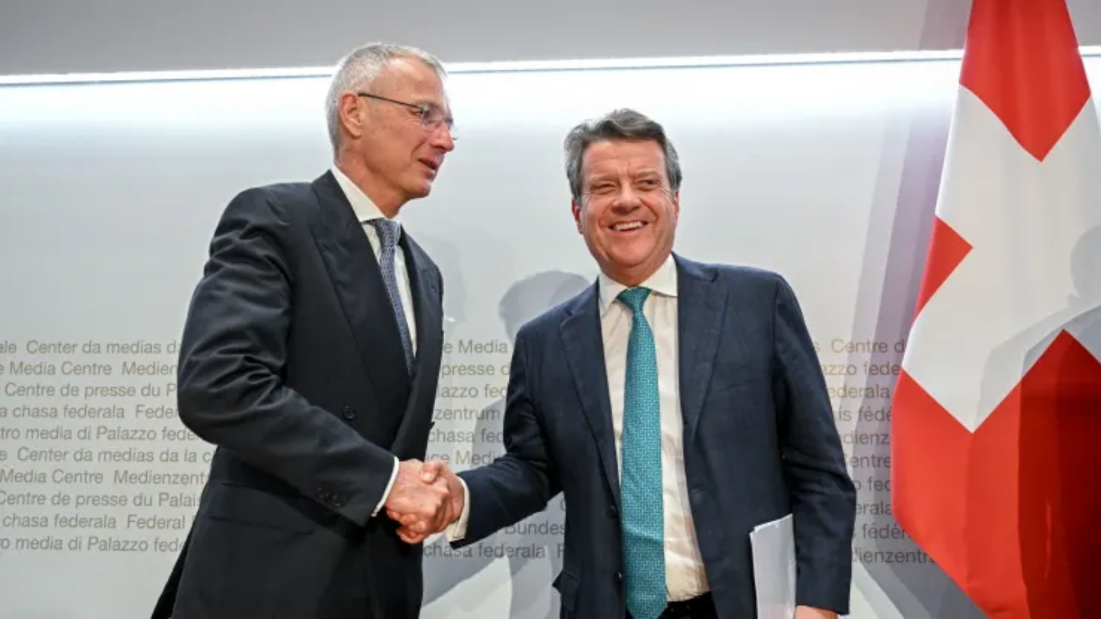 رئيس UBS كولم كيليهر (يمين) يصافح رئيس بنك كريدي سويس أكسل ليمان (يسار) بعد مؤتمر صحفي عقب محادثات حول Credit Suisse في برن في 19 مارس 2023.