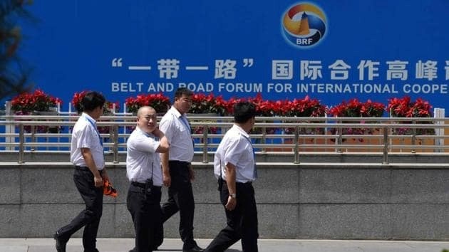 مسؤولون يسيرون خارج مركز الصين الوطني للمؤتمرات حيث تنعقد في العادة جلسات منتدى الحزام والطريق للتعاون الدولي، في بكين