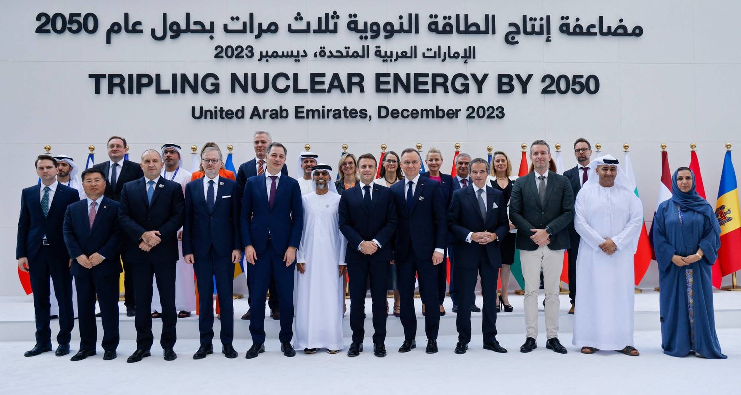 الرئيس الفرنسي إيمانويل ماكرون (في الوسط) يقف لالتقاط صورة مع القادة الآخرين والمشاركين في نهاية جلسة مضاعفة الطاقة النووية ثلاث مرات بحلول عام 2050 في قمة الأمم المتحدة للمناخ في دبي 