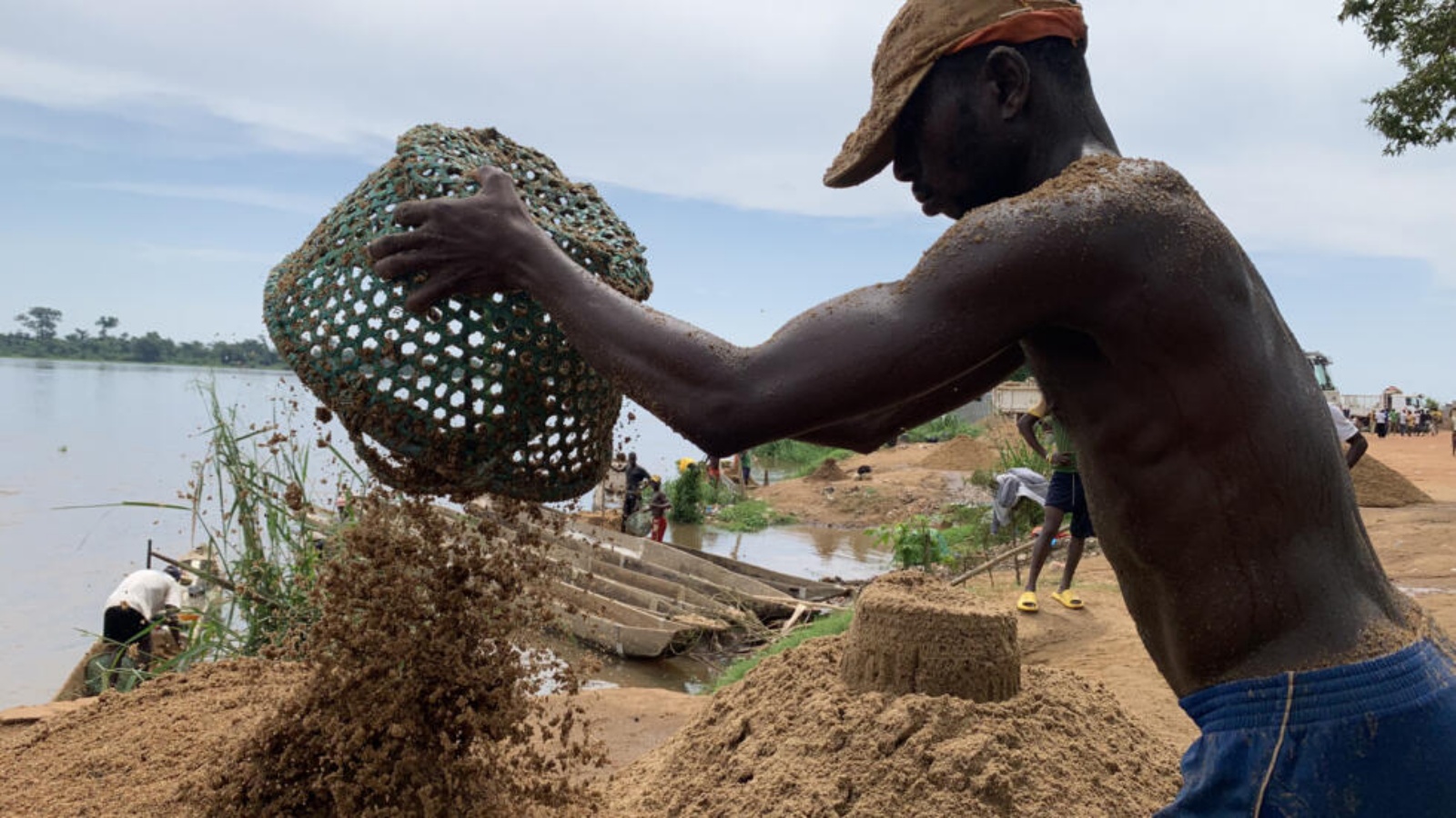 أوديلون سليمة يفرغ سلة مليئة بالرمل بعد جمعه من ضفاف نهر أوبانغي في بانغي عاصمة جمهورية أفريقيا الوسطى في 8 تشرين الثاني (نوفمبر) 2023 