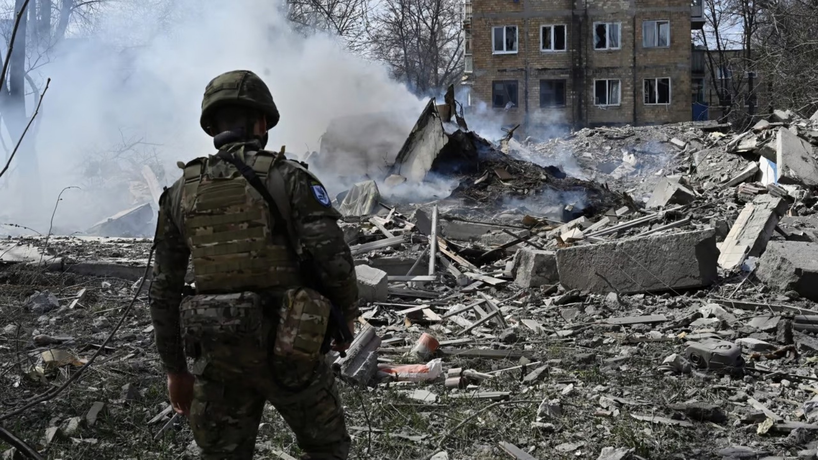 أحد أعضاء فريق الشرطة الخاصة للملائكة البيضاء الأوكرانية ينظر إلى حطام مبنى سكني، دمر في أعقاب غارة جوية على بلدة أفدييفكا الواقعة على خط المواجهة