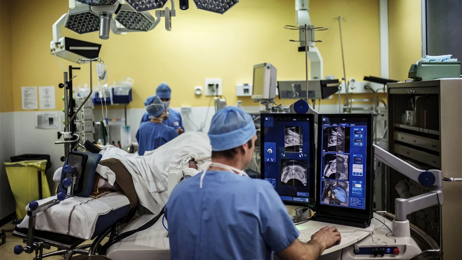 جراح يجلس أمام شاشات جهاز Focal One يقوم بإجراء عملية استئصال ورم البروستاتا بمساعدة الروبوت باستخدام التصوير بالموجات فوق الصوتية