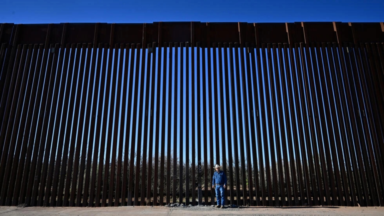 المزارع الأميركي جون لاد أما الجدار الحدودي بيم الولايات المتحدة والمكسيك بالقرب من بالوميناس في ولاية أريزونا الأميركية في 17 نيسان (ابريل) 2024 