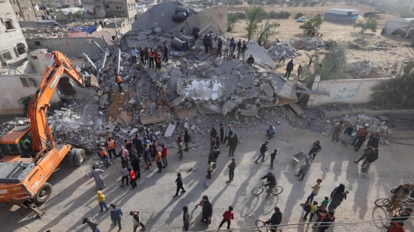 عناصر إنقاذ يبحثون عن ناجين بين أنقاض مبنى أصيب بقصف إسرائيلي خلال الليل في رفح جنوب قطاع غزة، 21 نيسان (أبريل) 2024 