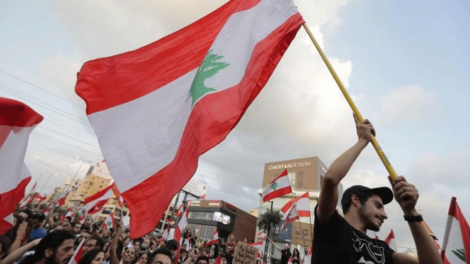 متظاهرون لبنانيون يرفعون الأعلام الوطنية على طريق سريع يربط بيروت بشمال لبنان، في منطقة زوق مكايل. 19 تشرين الأول\ اكتوبر2019