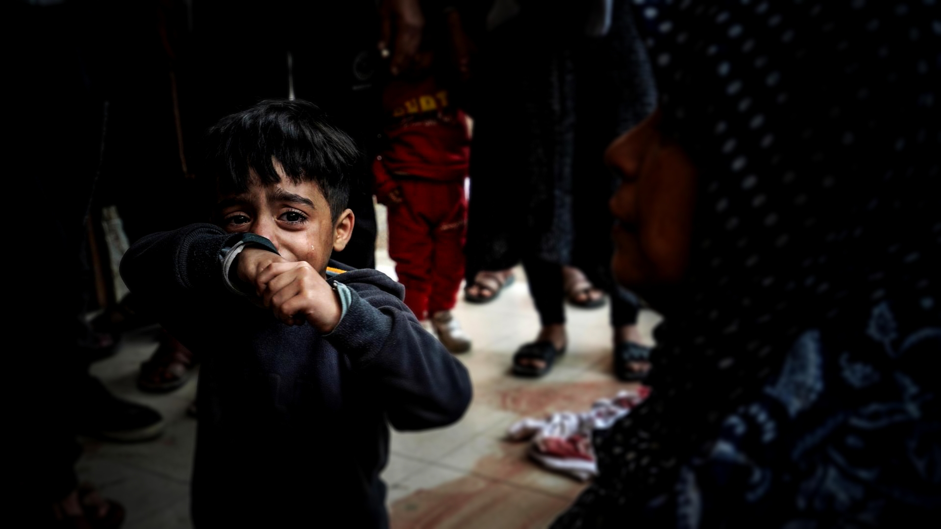 طفل يبكي، وسط حزن الناس على أحبائهم الذين قتلوا خلال القصف الإسرائيلي في مستشفى ناصر في خان يونس يوم 27 ديسمبر. أ ف ب