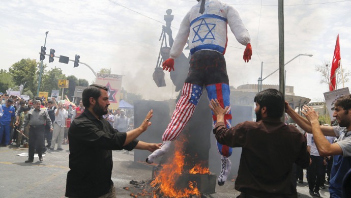 صورة أرشيفية لمظاهرة إيرانية في العام 2016 في طهران، حيث أقدم المتظاهرون على حرق دمية مزينة بأعلام إسرائيل وأميركا وبريطانيا. أ ف ب