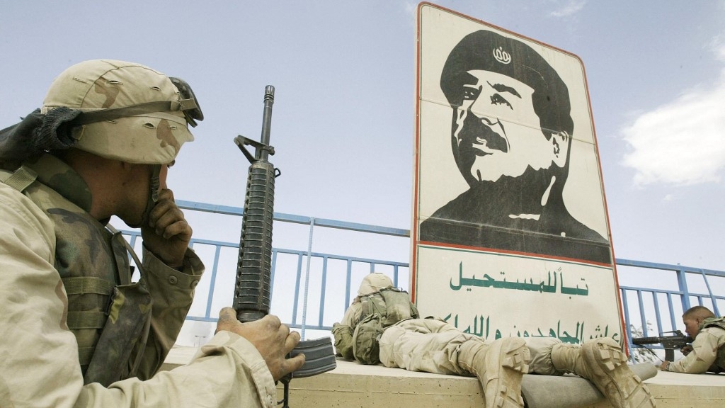 جنود أميركيون يتمركزون في العاشر من نيسان (أبريل) 2003 بالقرب من صورة لصدام حسين في بغداد