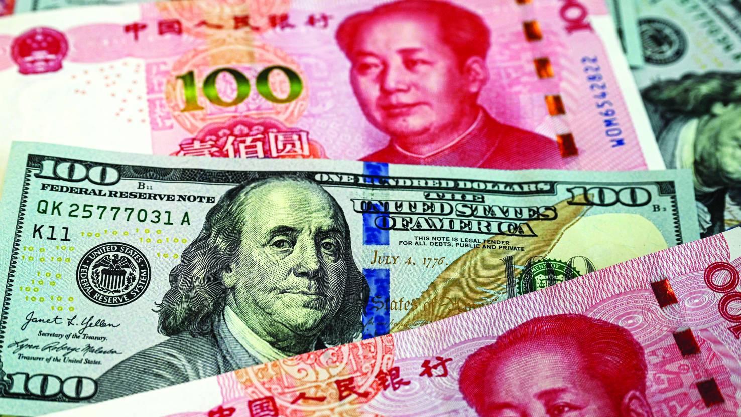 أوراق نقدية من فئتي الـ100 يوان الصينية والـ100 دولار الأميركية في بكين