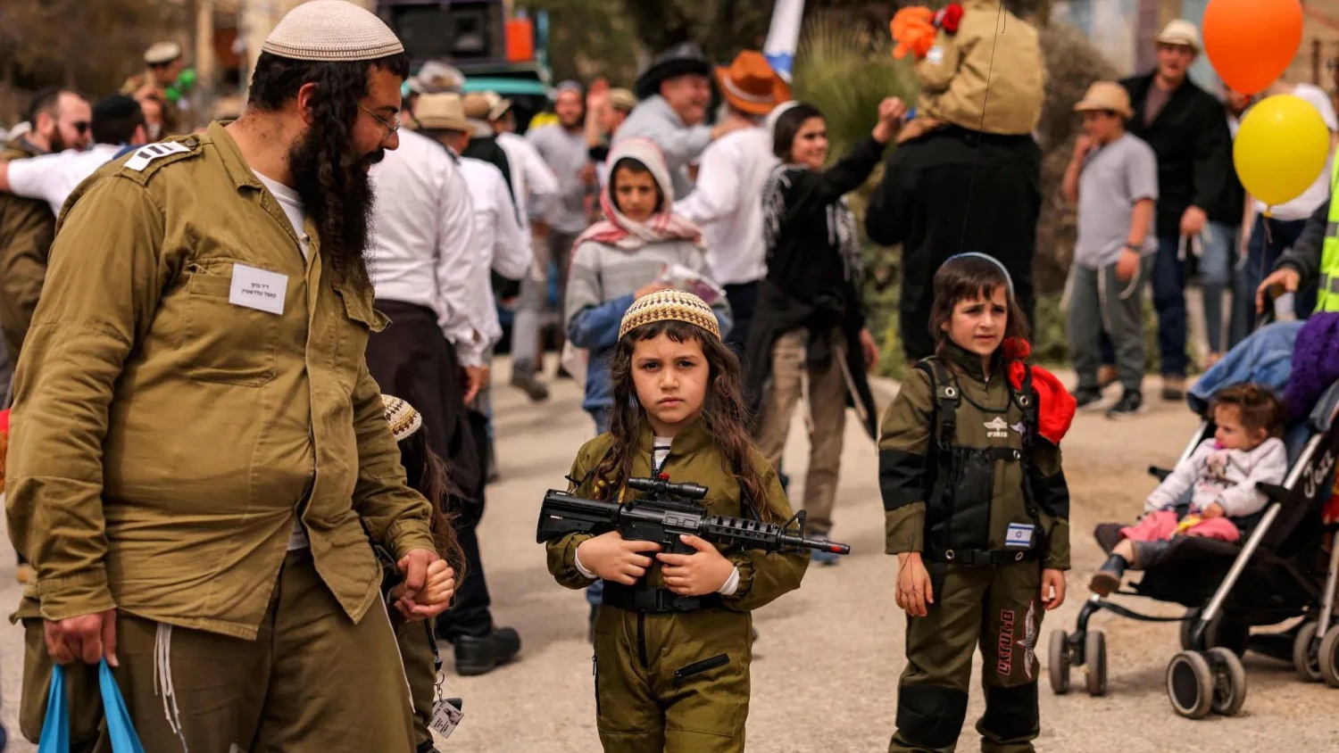 صبي إسرائيلي يحمل لعبة على هيئة بندقية في مدينة الخليل بالضفة الغربية المحتلة