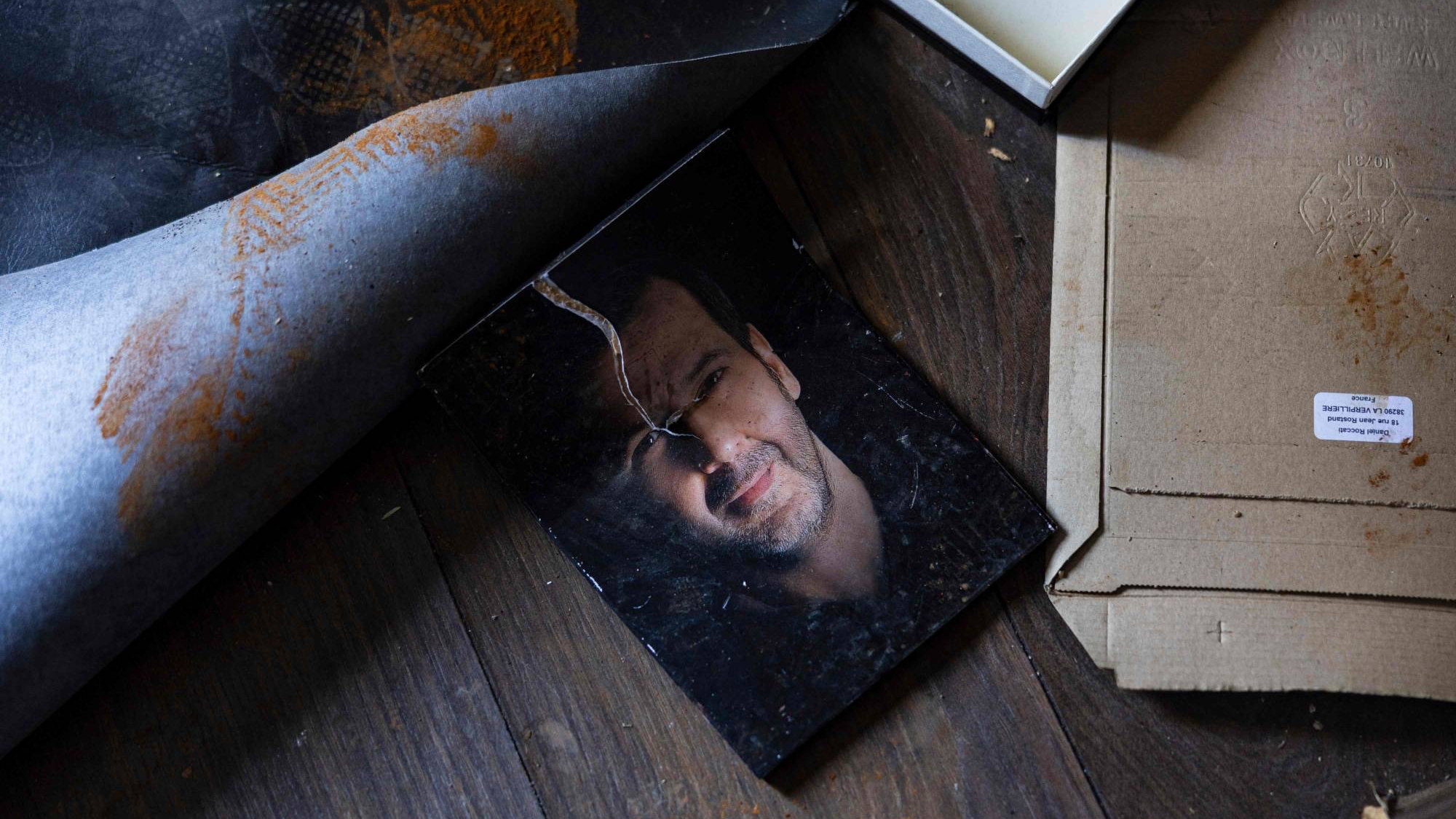 صورة ممزقة لماهر الأسد، شقيق الرئيس السوري بشار الأسد، ملقاة على الأرض في فيلته في بلدة يعفور