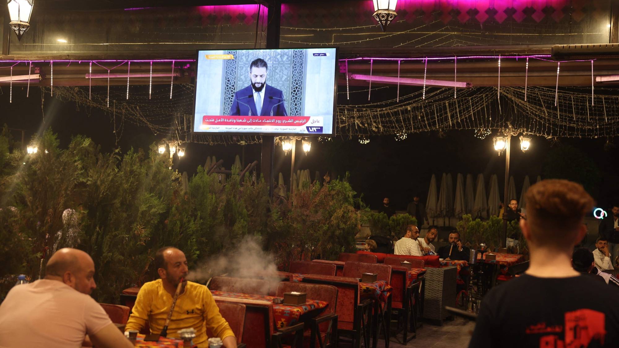 سوريون يشاهدون خطاباً متلفزاً للشرع في مقهى بحلب