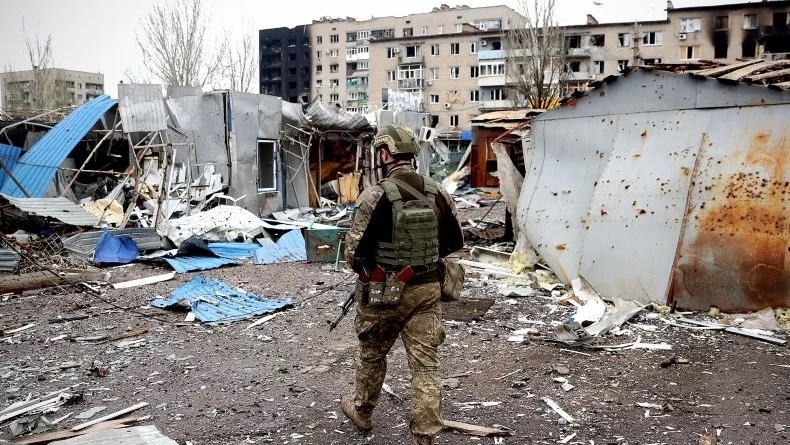 جندي أوكراني يسير بالقرب من مبنى سكني تضرر جراء القصف في مدينة باخموت
