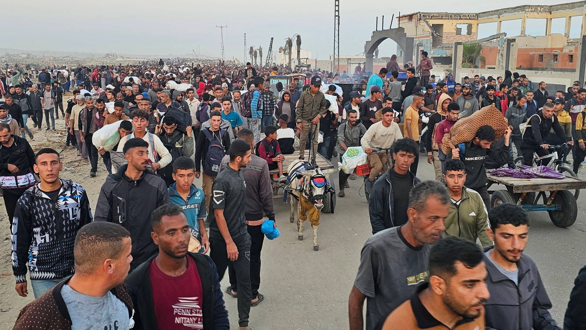 نازحون فلسطينيون يعودون من مركز توزيع مساعدات غذائية في رفح جنوب قطاع غزة