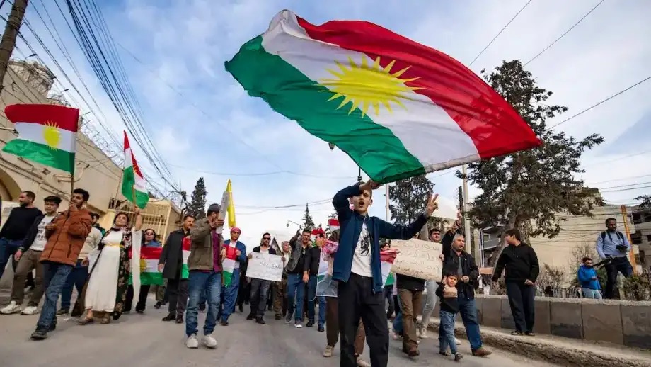 أكراد سوريون يلوحون بالأعلام أثناء تظاهرهم في مدينة القامشلي شمال شرق البلاد
