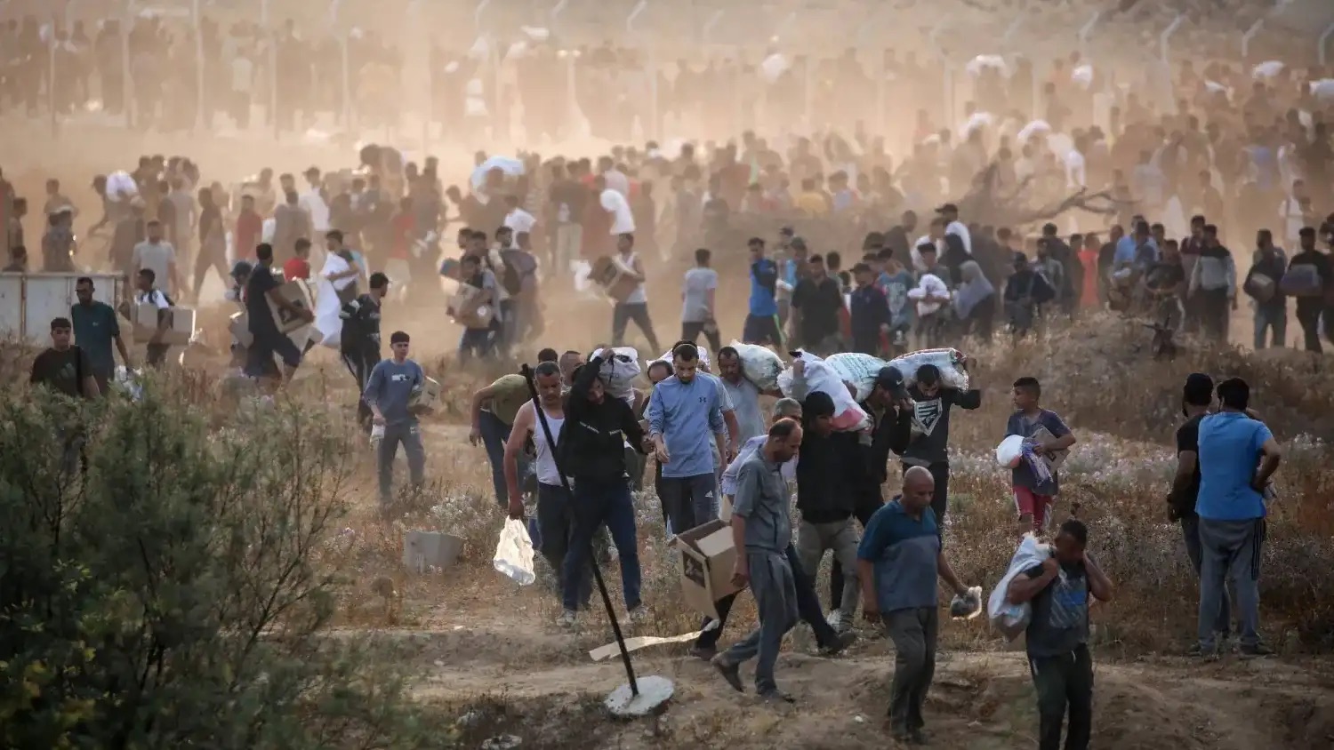 فلسطينيون يحملون معونات