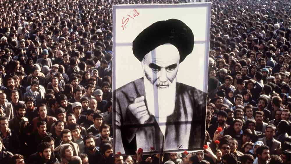 متظاهرون في طهران يحملون صورة الخميني في خضم التظاهرات الشعبية ضد شاه إيران التي أفضت إلى إسقاطه في عام 1979