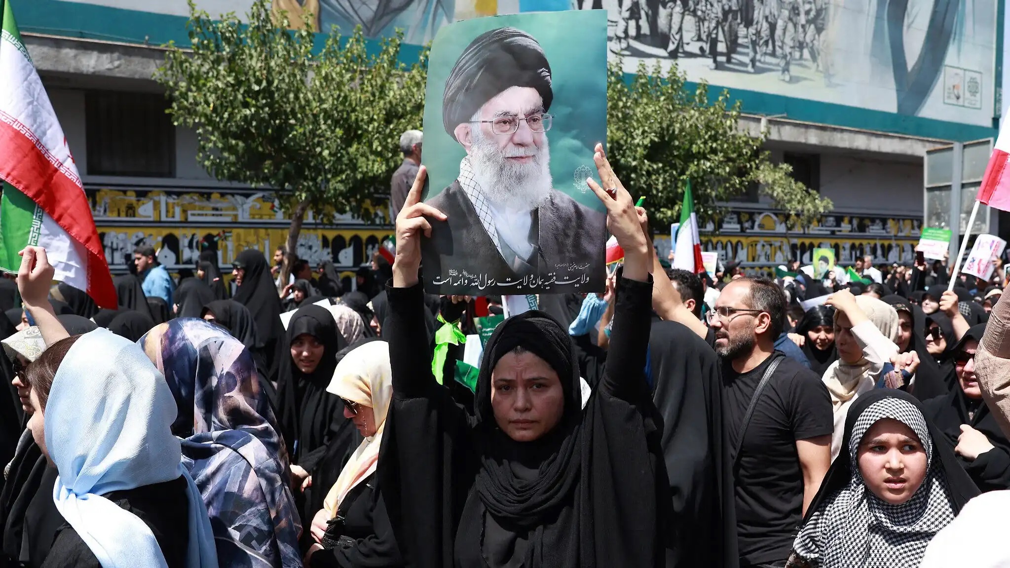 إيرانية ترفع صورة المرشد الأعلى الإيراني علي خامنئي خلال مظاهرة مناهضة لإسرائيل في طهران في 20 حزيران (يونيو) 2025