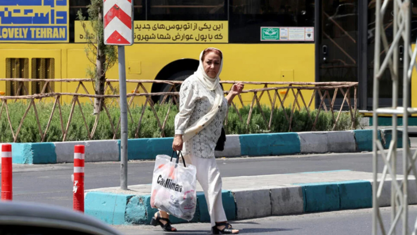 امرأة تجتاز طريقاً في طهران اليوم