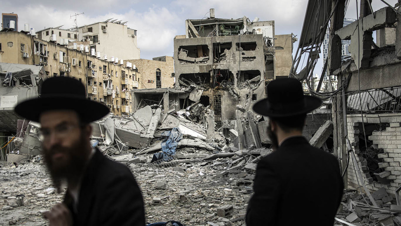 رجال دين يهود يتفقدون الأضرار في موقع هجوم صاروخي إيراني في بني براك، شرق تل أبيب