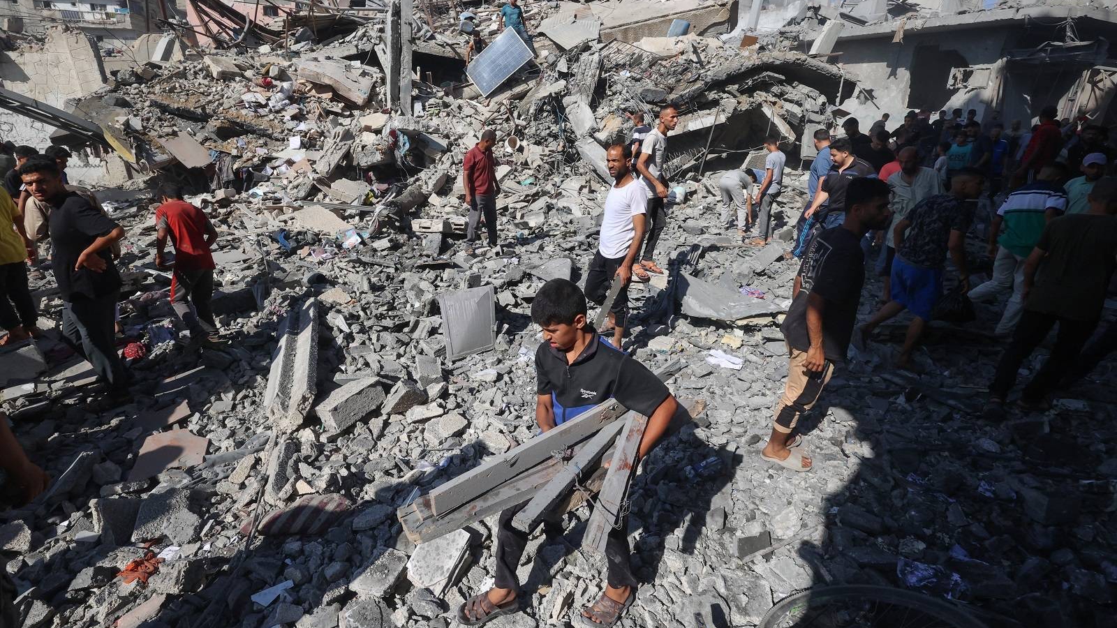 فلسطينيون يتفقدون أنقاض منزل تضرر جراء غارة إسرائيلية على مخيم البريج للاجئين الفلسطينيين وسط غزة