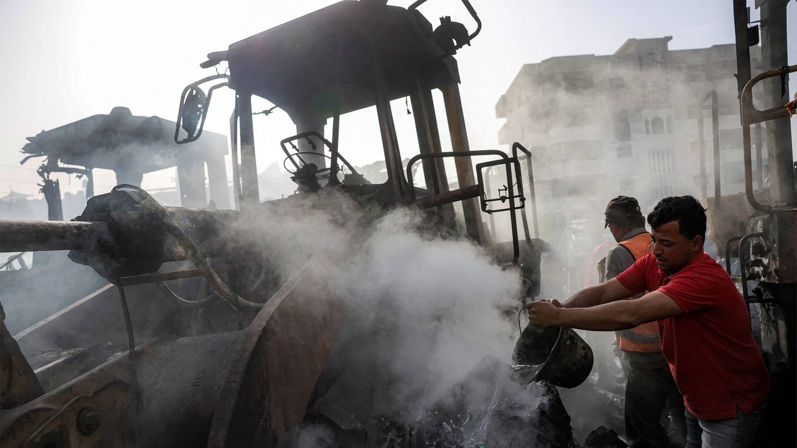 فلسطيني يحاول إطفاء حريق بحفارات استهدفتها غارات إسرائيلية في جباليا شمال غزة