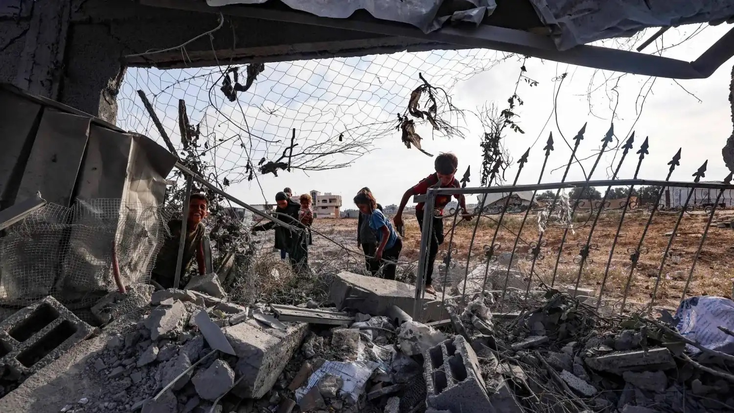 أطفال فلسطينيون يتفقدون أنقاض مبنى تضرر في غارة إسرائيلية على مخيم البريج للاجئين بوسط قطاع غزة