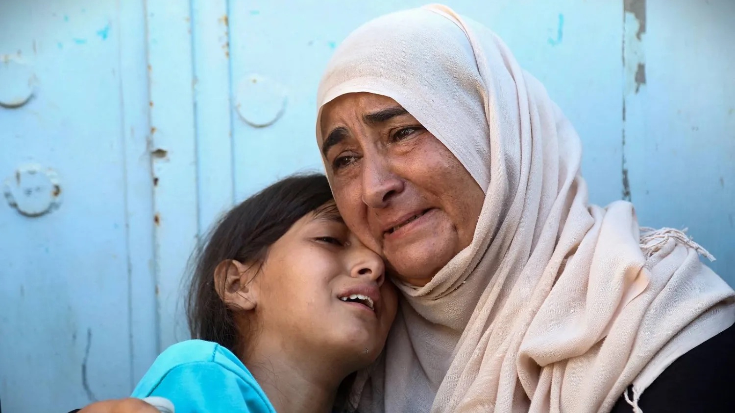 رد فعل فلسطينية وابنتها عقب مقتل أحد أقربائهما في غارات إسرائيلية على خان يونس