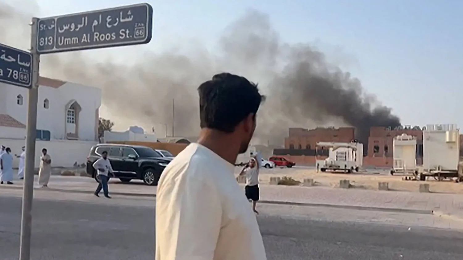 رجل يراقب الدخان المتصاعد من الانفجارات التي أعقبت الهجوم الإسرائيلي في الدوحة