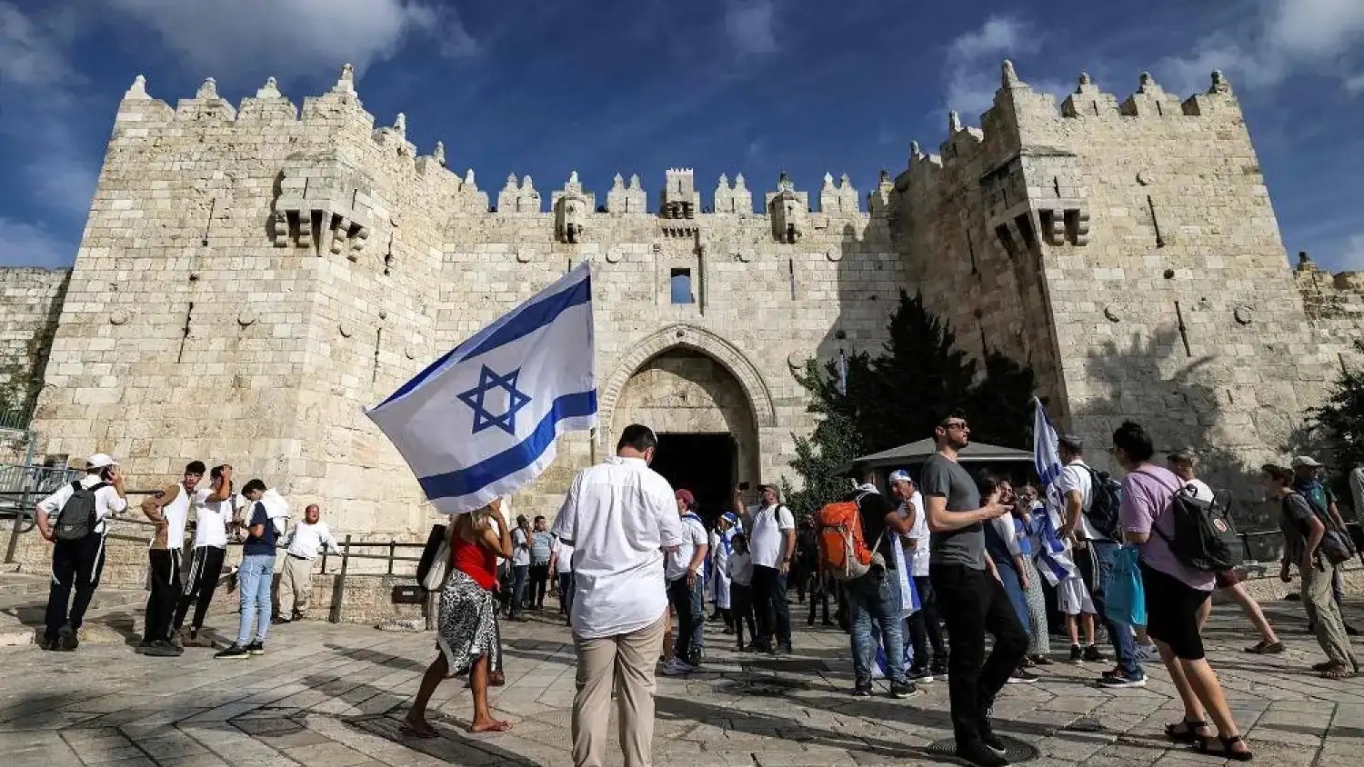 إسرائيليون يلوحون بالأعلام الوطنية أمام باب العامود المؤدي إلى البلدة القديمة في القدس خلال 