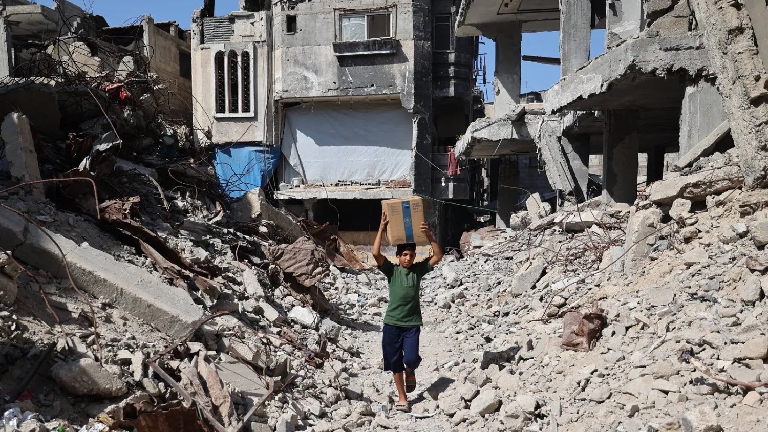 طفل فلسطيني يحمل صندوقاً من الإمدادات الطارئة التي قدمها برنامج الغذاء العالمي وسط قطاع غزة