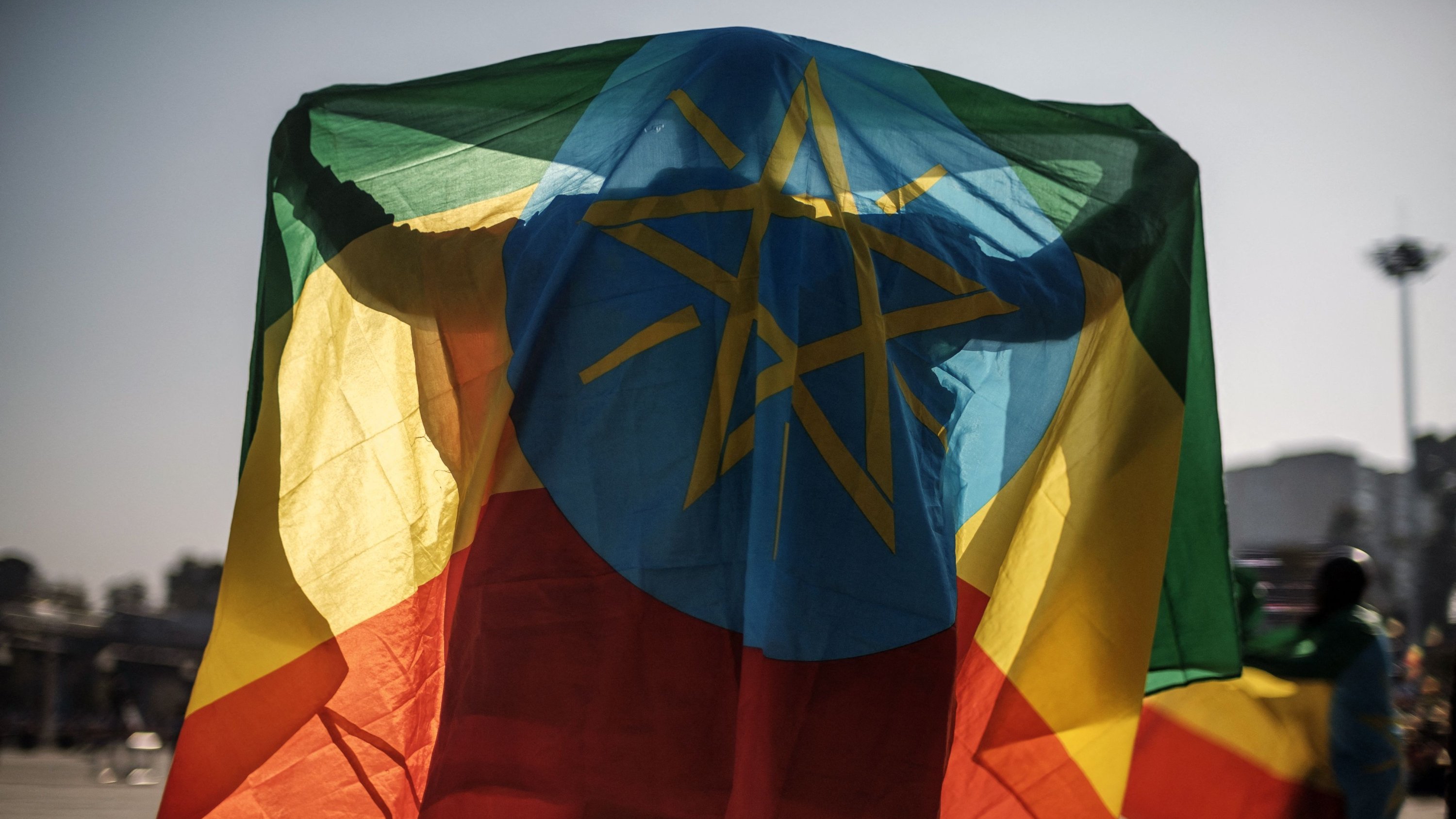 رجل يتلفع بالعلم الإثيوبي خلال مسيرة لدعم قوات الدفاع الوطني، أديس أبابا، إثيوبيا، 7 تشرين الثاني (نوفمبر) 2021