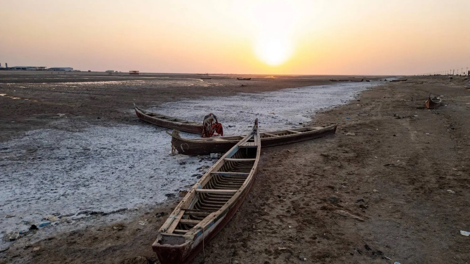قوارب صيد خشبية تقليدية مهجورة في أهوار جافة بمحافظة البصرة جنوب العراق