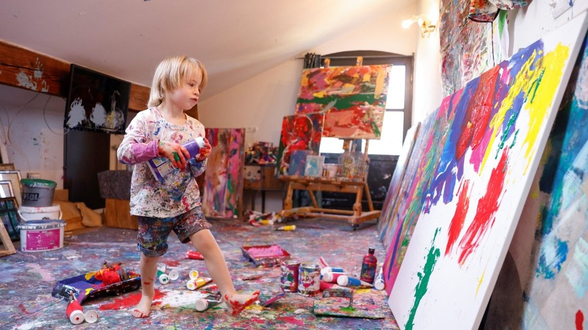 طفل يلهو بالألوان في مرسم ذويه