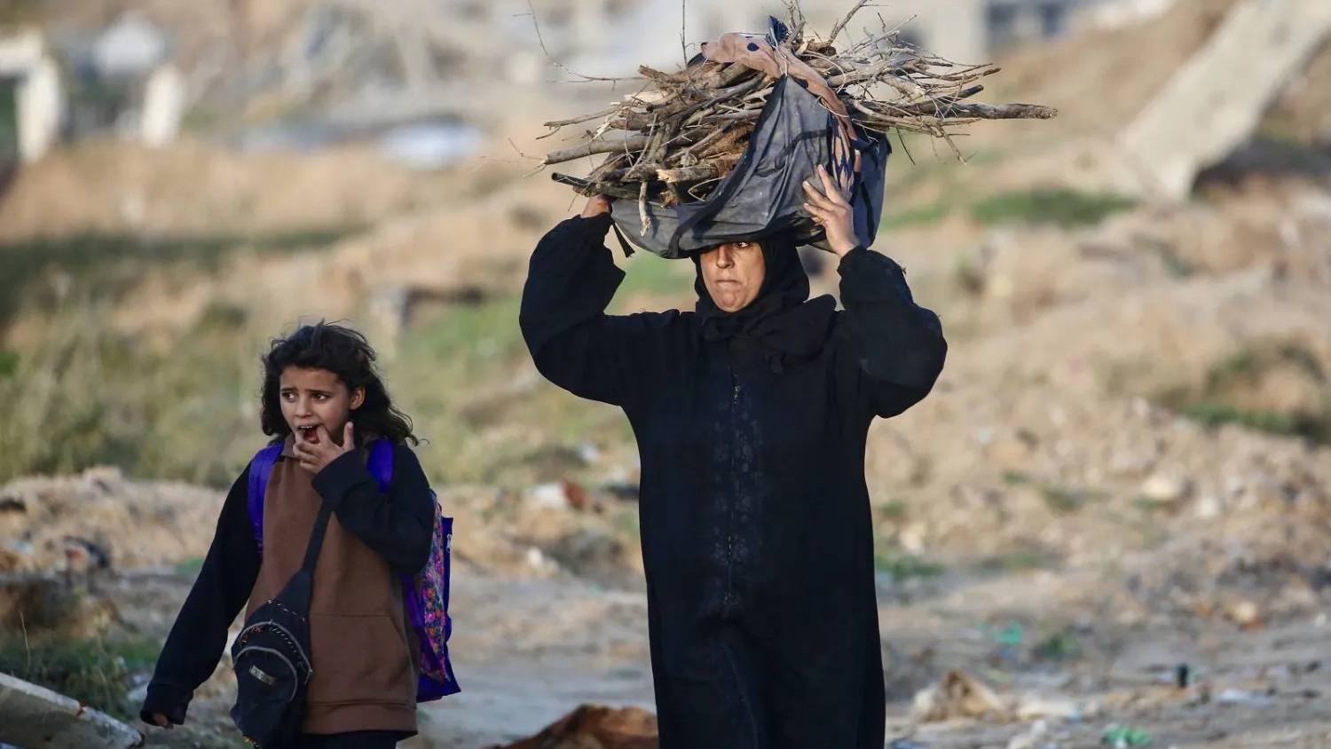 امرأة فلسطينية تحمل حطباً لإشعال النار في مخيم النصيرات للاجئين وسط قطاع غزة