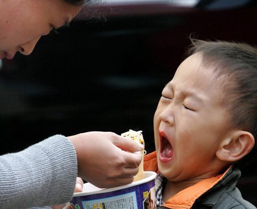 أم صينية تطعم طفلها المعكرونة