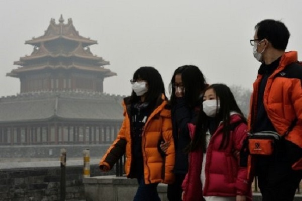 سياح صينيون يرتدون اقنعة واقية خلال تجولهم في بكين 