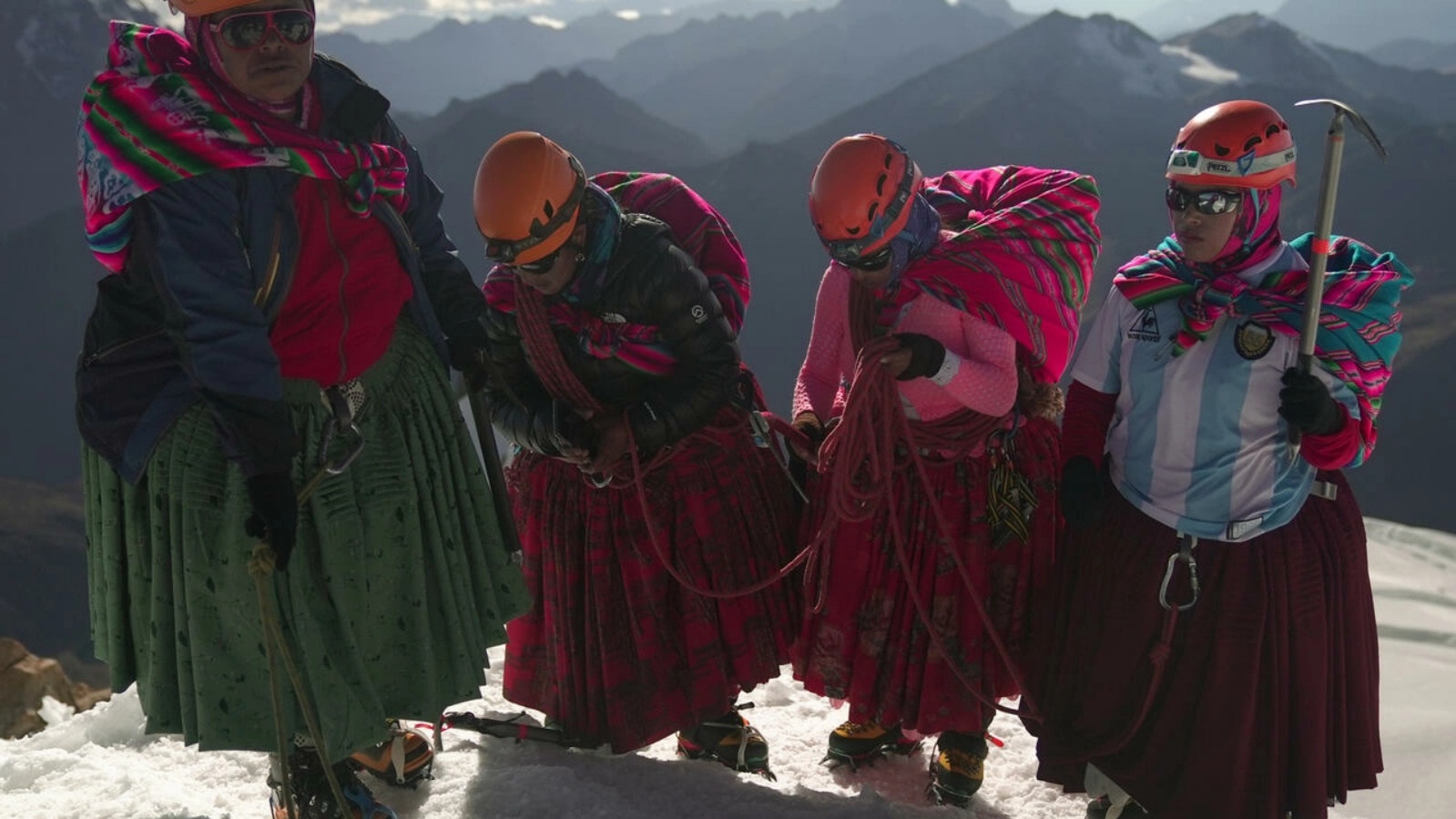 (من اليسار إلى اليمين) أديلا يوسكو، وسينوبيا يوسكو، وسيسيليا يوسكو، وكاميلا تاركوي يوسكو، من نساء أيمارا من السكان الأصليين يقمن بتسلق تشوليتاس في بوليفيا وارميس، في قمة جبل هواينا بوتوسي الذي يبلغ ارتفاعه 6.088 مترًا