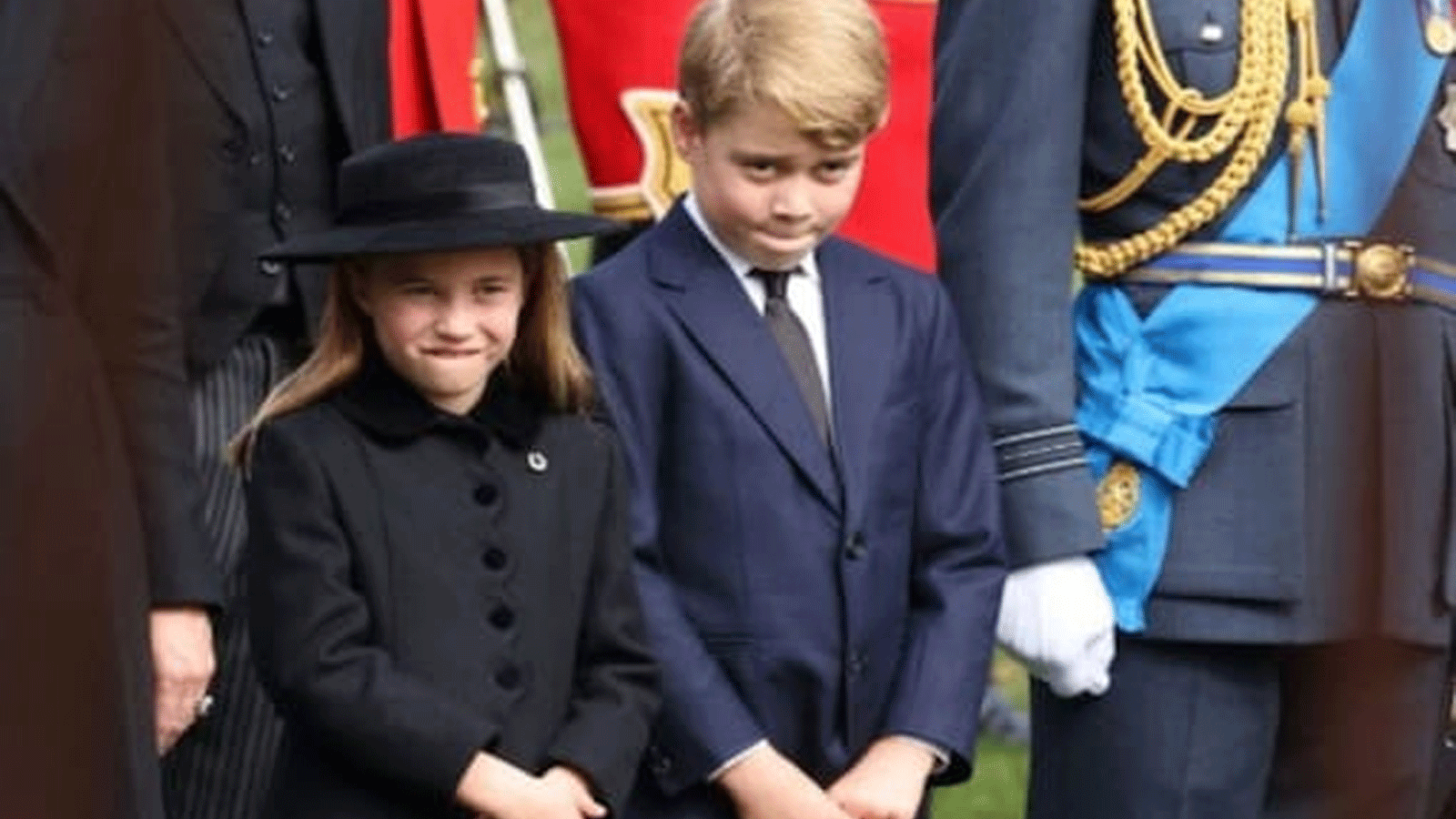 الأمير جورج، تسعة أعوام، والأميرة شارلوت، سبع سنوات، يسيران مع والدتهما كاثرين، أميرة ويلز والأب ويليام، أمير ويلز، الذي أصبح الأول في ترتيب العرش بعد الملك تشارلز الثالث