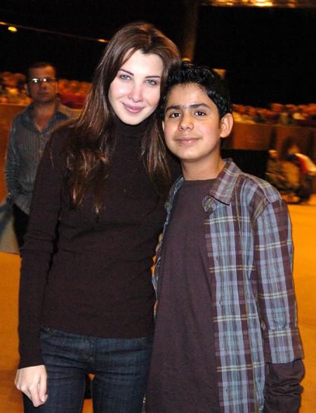 اصورة نانسي مع االفنان الصغير قصي لعراقي وتبدو دموعها على خدها