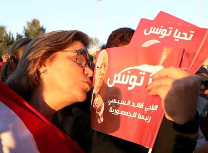 شابة تونسية تقبل صورة السبسي - AFP